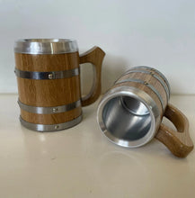 Two views of a wooden beer mug with a stainless steel insert, hoops and handle.
